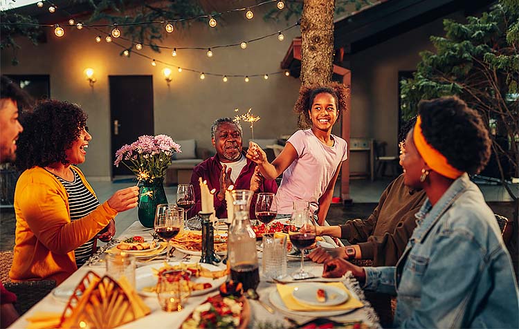 Family around table while girl entertains with sparkler