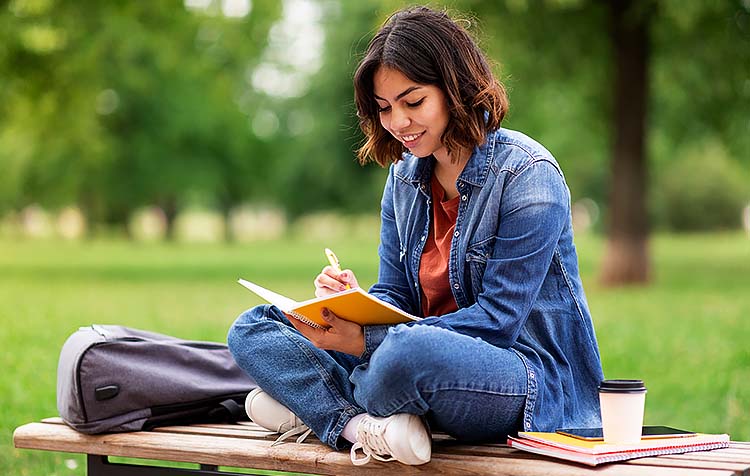 Young woman writing in notebook