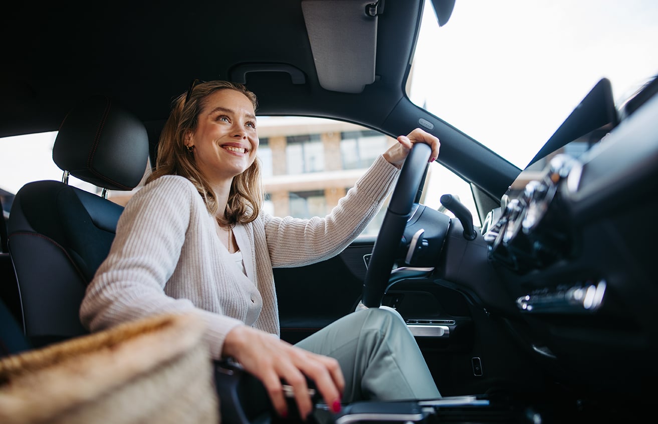 man in a car adjusting settings