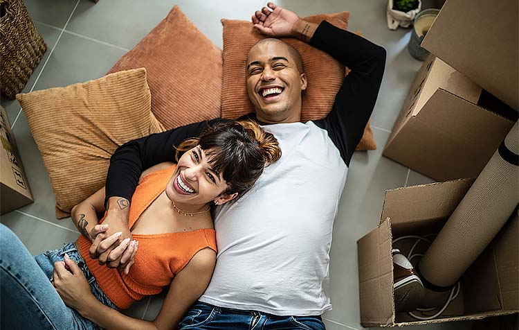 Happy couple laying on floor of new home