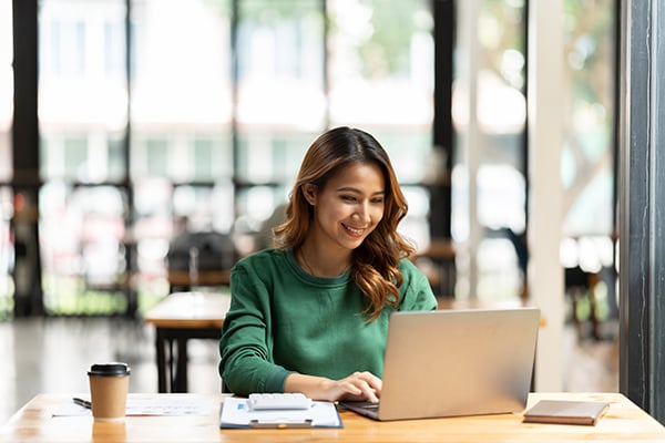woman happily working on her laptop